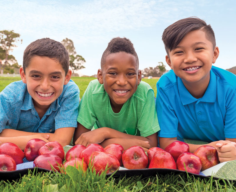 three boys with apples