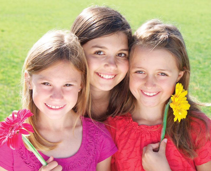 three girls holding flowers